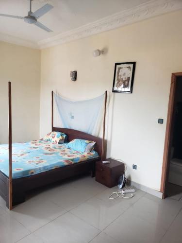 Abomey-CalaviAgimdeluxe的一间卧室配有一张木架床