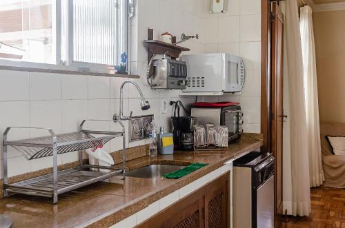 彼得罗波利斯Chamosa e aconchegante casa em Petrópolis VGL041的厨房柜台设有水槽和微波炉