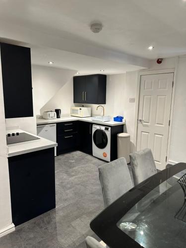 德比Modern 2 Bedroom Apt Derby City的厨房配有黑白电器和桌椅
