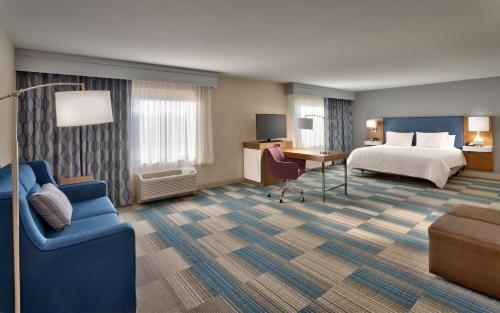 波卡特洛波格太罗汉普顿套房酒店的酒店客房配有一张床、一张书桌和一张沙发。