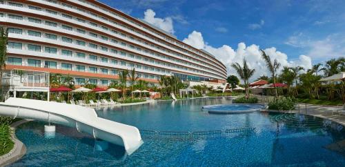 北谷町冲绳北谷希尔顿度假酒店的一座大型酒店,在游泳池里设有滑梯
