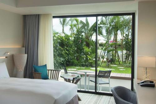 北谷町冲绳北谷希尔顿度假酒店的酒店客房设有一张床,享有庭院的景色