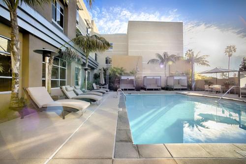 圣巴巴拉圣巴巴拉/戈利塔 - 希尔顿花园酒店的一座带躺椅的游泳池和一座建筑