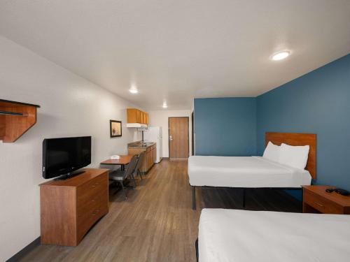 罗克沃尔WoodSpring Suites Dallas Rockwall的酒店客房设有两张床和一台平面电视。