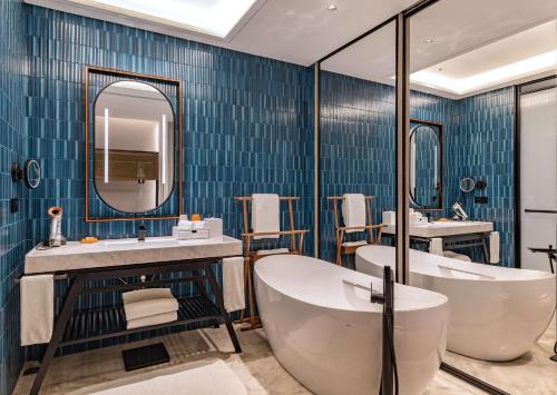 杭州杭州西湖希尔顿嘉悦里酒店（花园下午茶 网红餐厅酒吧）的带浴缸、水槽和镜子的浴室