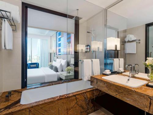 迪拜Pullman Dubai Downtown的一间带水槽和大镜子的浴室