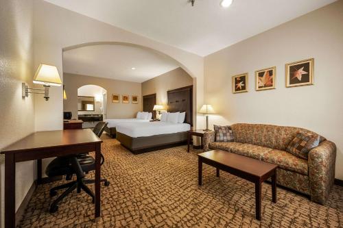 休斯顿温莎贝斯特韦斯特套房酒店的大型酒店客房,配有一张床和一张书桌