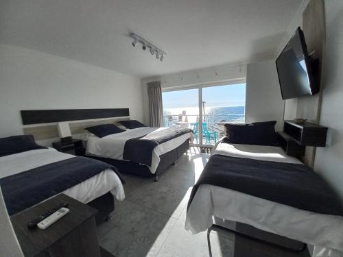 维纳德马Hotel Cocó Cochoa的酒店客房设有两张床和电视。