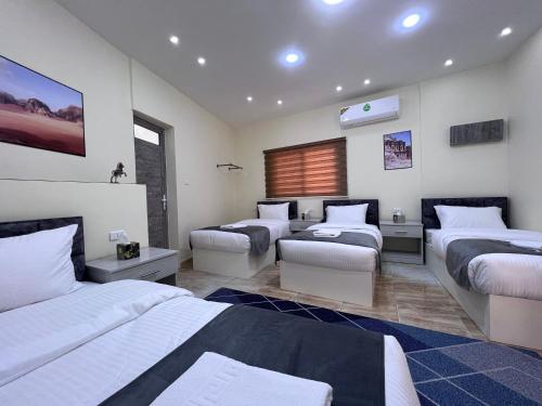 瓦迪穆萨Z3 Hostel的一间卧室设有三张床和客厅