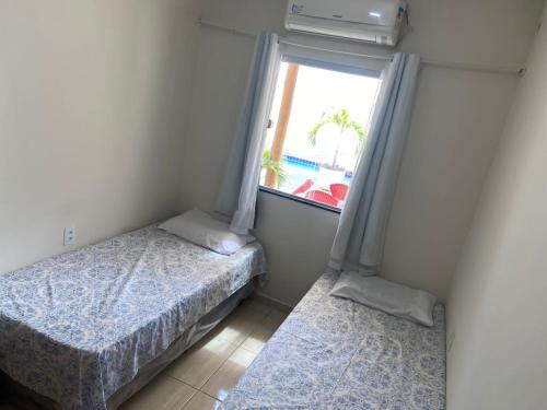 彼得罗利纳Linda Casa com piscina e totalmente climatizada Airbn b的一间小卧室,配有两张床和窗户