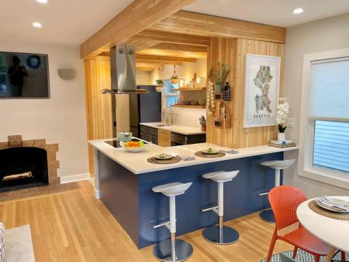 西雅图Cabin Vibes Condo in North Capitol Hill的厨房配有带凳子的柜台和壁炉。