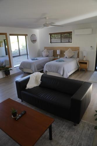 黄金海岸'Stay in Carrara' A private guest suite not a share house的一间带两张床和一张沙发的客厅