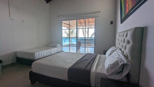 帕洛米诺Beach Life Palomino & Beach Club的一间卧室设有两张床和一个美景窗户。
