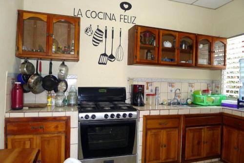 马塔加尔帕Matagalpa Tours Guest House的厨房配有木制橱柜和炉灶烤箱。