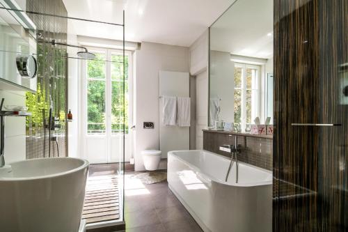 米卢斯Peonia at Home - Maison d'hôtes d'exception的白色的浴室设有浴缸和水槽。