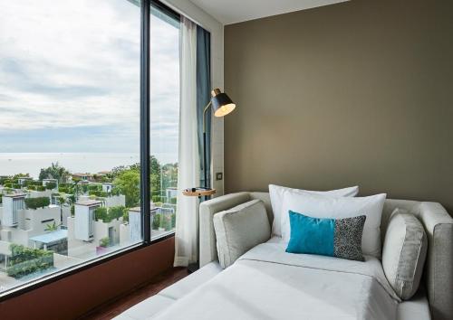 华欣华欣罗丽哥度假酒店的一间带沙发和大窗户的卧室