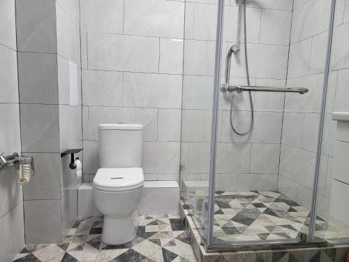 阿斯塔纳Толе Би 57 - ТРЦ Хан Шатыр的一间带卫生间和玻璃淋浴间的浴室
