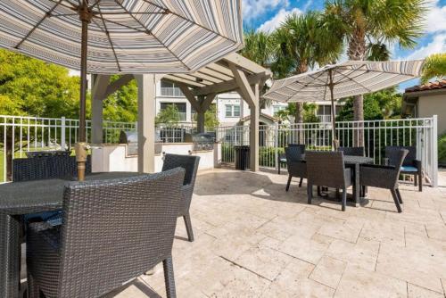 奥兰多Luxury Family Resort Styled Apartment Near Disney的一个带桌椅和遮阳伞的庭院