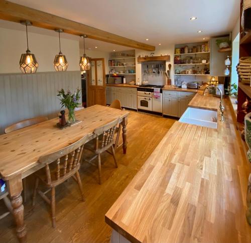 弗罗姆Cottage in the Heart of Frome的厨房配有大型木桌和椅子