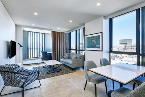 利物浦Meriton Suites Liverpool的客厅配有桌椅