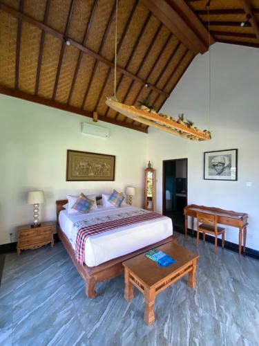 坎古普里香鱼酒店的一间卧室配有一张大床和一张桌子