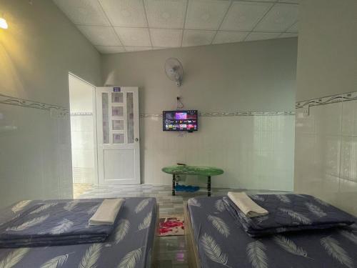 隆海Nhà nghỉ Thiên Thanh 1的客房设有两张床和一台墙上的电视。