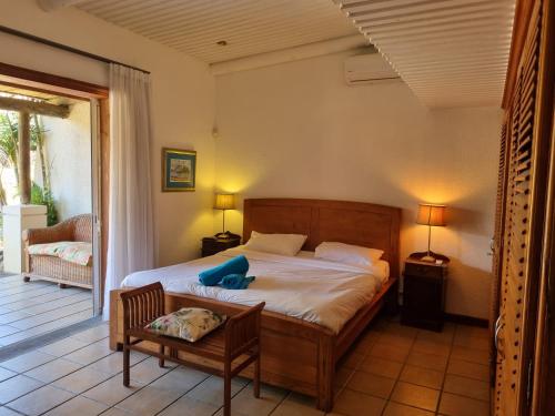 塔马兰香提小屋旅馆的一间卧室配有一张床、一把椅子和一个门廊