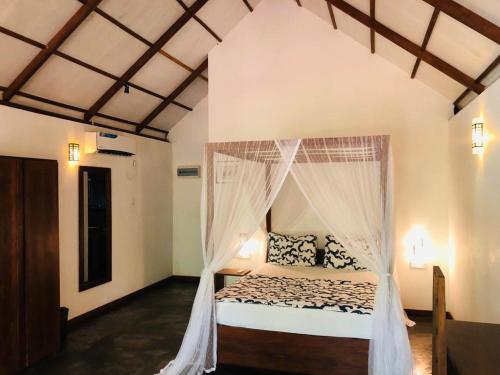 达瓦拉维The Countryside Udawalawe的一间卧室配有一张带蚊帐的床