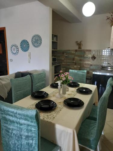 斯库台Panoramic apartment的餐桌、白色桌布和绿色椅子