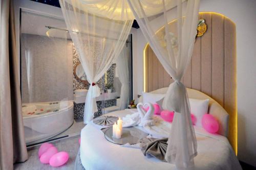 岘港Ngọc Bích Hotel Da Nang的一间卧室配有一张带蜡烛和浴缸的床。