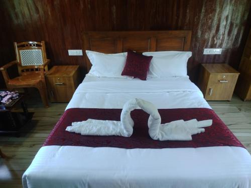 玛莱尤尔Don's River Valley Jungle Resort的一张大床,上面有两条白色毛巾