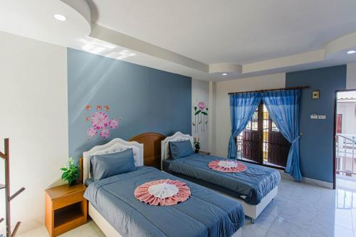 芭东海滩Pailin Hill Hotel的蓝色墙壁客房的两张床