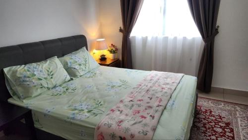 哥打丁宜Haiqal's Hometay @ Desaru (Muslim)的一间卧室配有一张带花卉棉被的床和窗户。