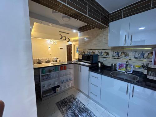 赫尔格达Apartment Hossam 1的厨房配有白色橱柜和水槽