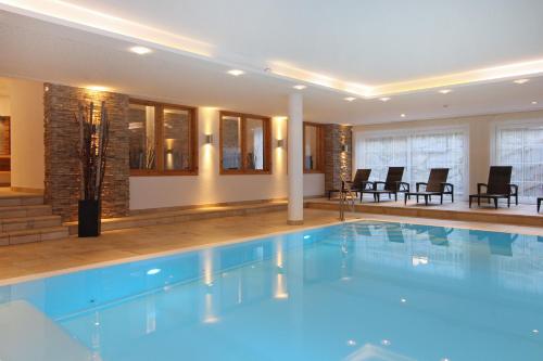 卡普伦AvenidA Mountain Resort by Alpin Rentals的一座配有桌椅的酒店游泳池