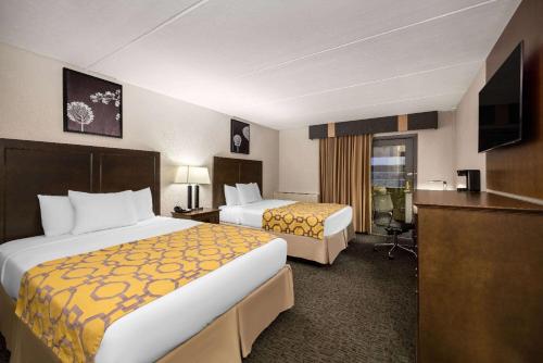 沙科皮Baymont by Wyndham Shakopee的酒店客房配有两张床和一张书桌