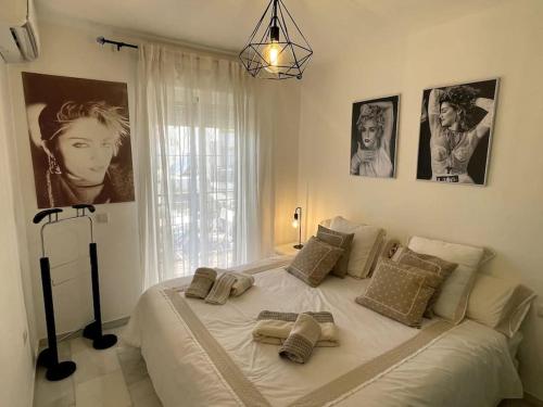 马拉加Málaga casa grande familiar的卧室内的一张白色大床,墙上挂着照片