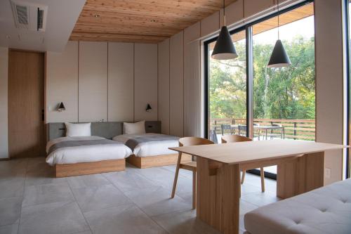 ShioSOOTHE FOREST的一间卧室配有两张床和一张桌椅