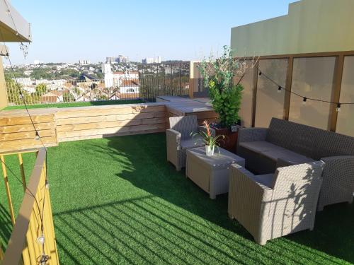 巴纽La Terrasse - big apartment & terrace 80m2 - metro 17 min from Paris的一座带椅子和草地的屋顶露台
