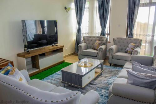 尼亚利Lux Suites Impala Apartments Nyali的客厅配有白色家具和平面电视