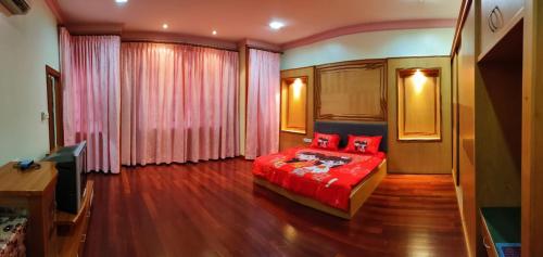 诗巫R&S Homestay Sibu - Wedding House with Large Parking Area and High Speed Unifi的一间卧室配有红色的床和电视