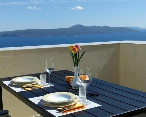 莫什尼卡德拉加Holiday house Mavi -Obrs Moscenicka Draga,Riviera Opatija的一张桌子,上面有盘子和花瓶