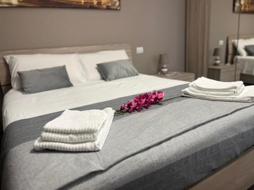 博洛尼亚Sweet Home 051的床上有毛巾和鲜花