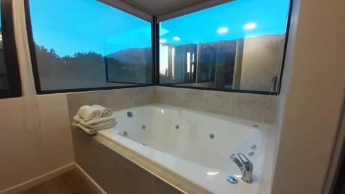 梅洛阿尔图斯德尔索尔Spa度假酒店的带浴缸的浴室和窗户