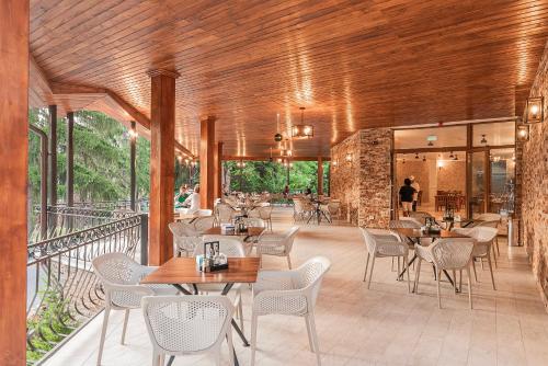 百乐·奥拉内斯蒂Hotel Cascada BAILE OLANESTI的阳台餐厅,配有桌椅