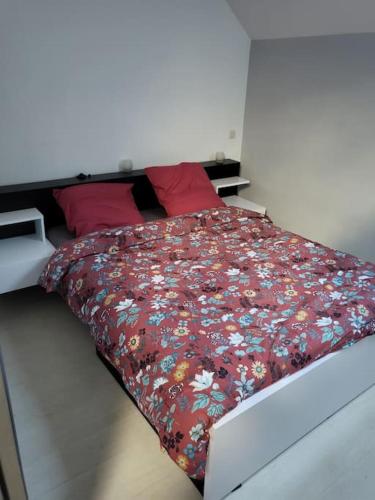 Bôo-SilhenDu bon temps的卧室内的一张带花卉棉被的床