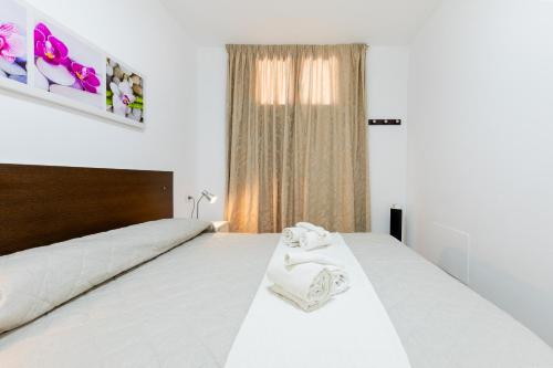 法纳贝海滩Las Americas Acapulco 4 Costa Adeje的一间卧室配有一张带白色床单的床和一扇窗户。