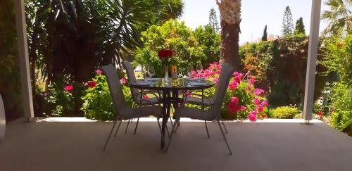 珊瑚湾CORAL BAY suite Cyprus的鲜花庭院里的桌椅