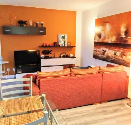 帕莱索海滩Adeje300, Playa Paraíso的客厅设有橙色墙壁和沙发