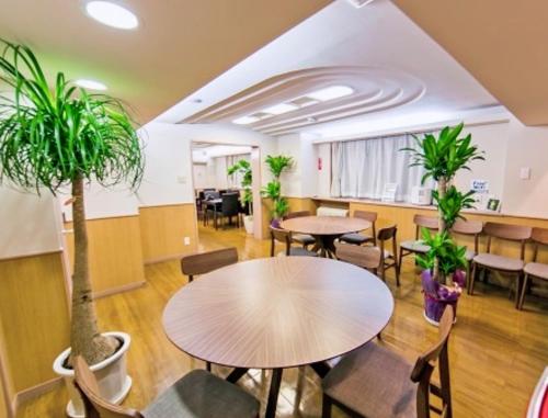 东京Hotel Yuni -Comfortable stay Star-Club iD的配有桌椅和盆栽的办公室